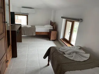 a small room with two beds and a window at Къща за гости Стиляна in Devin