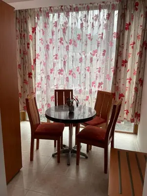 a table and chairs in a room with a window at Къща за гости Стиляна in Devin