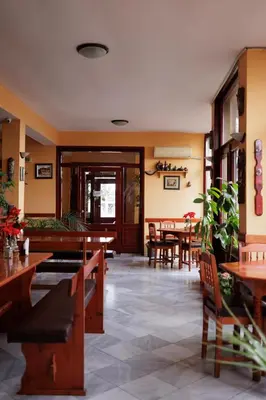 a restaurant with wooden tables and chairs and a dining room at Trafi Em in Sofia