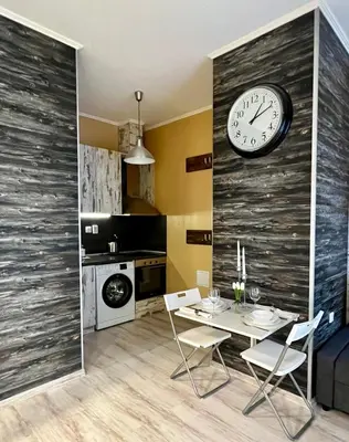 a dining room with a table and a clock on a wall at Flower home 1 in Sofia