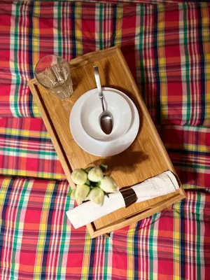 a plate and a spoon on a wooden tray on a couch at Flower home 1 in Sofia