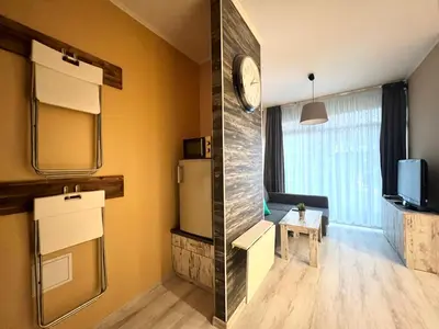 a room with a refrigerator and a tv in it at Flower home 1 in Sofia