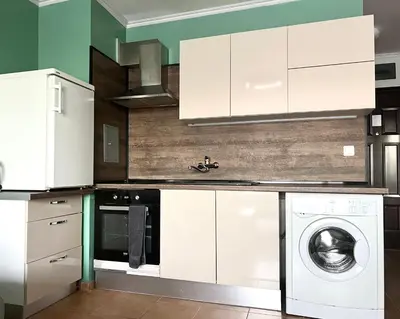 a kitchen with white cabinets and a washing machine at Flower home 2 in Sofia