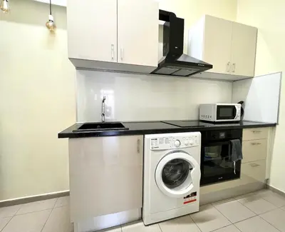 a kitchen with a washing machine and a microwave at Flower home 4 in Sofia