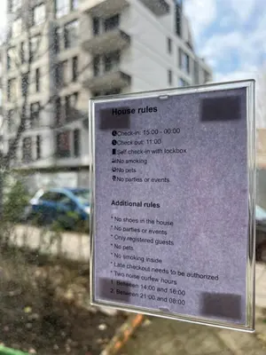 a sign for a house rules in front of a building at Flower home 4 in Sofia