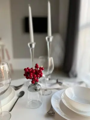 a table with wine glasses and a vase with red berries at Flower home 5 in Sofia