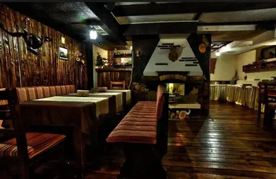 a restaurant with tables and a fireplace in a room at Deluxe Apartment in Bansko