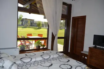 a bedroom with a bed and a large window at Gostnici Holiday Home in Razlog
