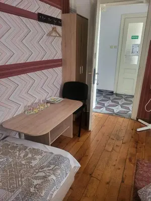 a room with a table and a bed and a door at Hostel Alex 1 in Sofia