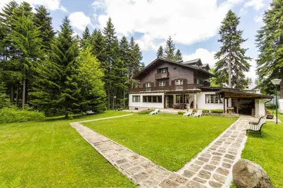 a large house with a green lawn in front of it at Villa Kalia in Borovets