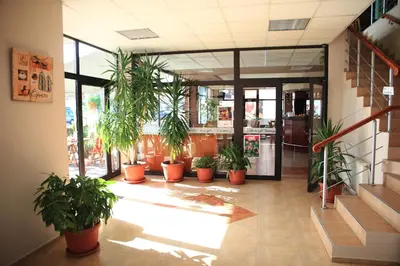 a lobby with potted plants in a building at Hotel Grand in Samokov