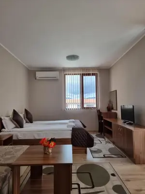 a living room with two beds and a tv at Andreevite Houses in Sapareva Banya