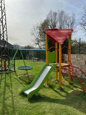 a playground with a slide in the grass at Family Hotel Ognyanovo in Ognyanovo