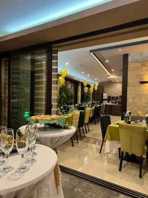 a restaurant with white tables and chairs and a large window at Family Hotel Ognyanovo in Ognyanovo
