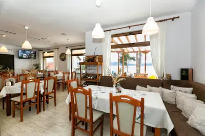a restaurant with tables and chairs and a couch at Villa Santa Maria in Tsigov Chark