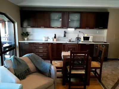 a kitchen with a couch and a table in a room at Apartments Elegance in Bansko