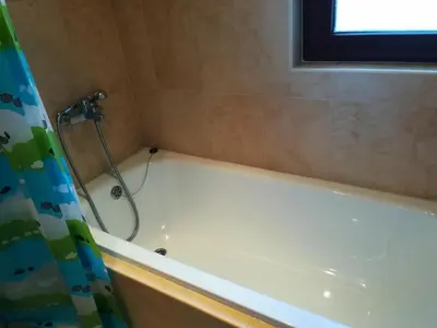 a bathroom with a bath tub with a shower curtain at Apartments Elegance in Bansko
