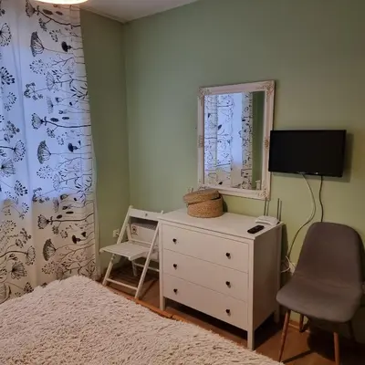 a bedroom with a bed and a dresser and a mirror at Apartments Elegance in Bansko
