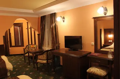 a hotel room with a bed and a desk with a television at Stoichkovata Kashta Koprivshtitsa in Koprivshtitsa