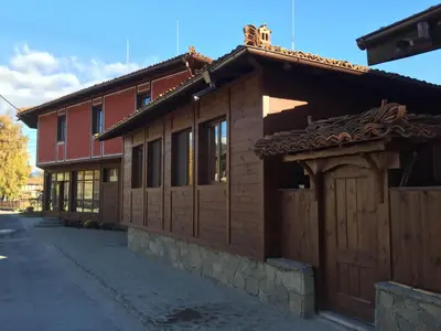 a building with a wooden fence next to a street at Stoichkovata Kashta Koprivshtitsa in Koprivshtitsa