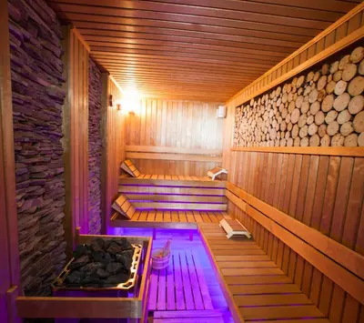 a sauna with purple lights in a wooden room at Amira Boutique Hotel in Bansko