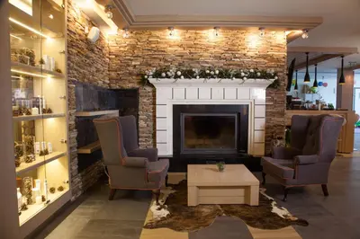a living room with two chairs and a fireplace at Amira Boutique Hotel in Bansko