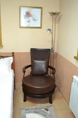 a brown chair sitting in a corner with a lamp at Guest House Secession Style in Sofia