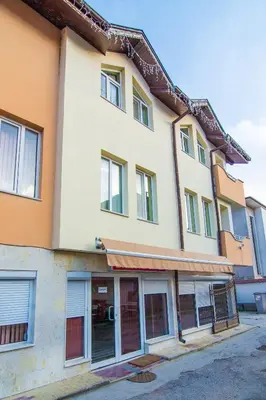 a building with windows and doors on a street at Family Hotel Victoria Gold in Mineralni Bani