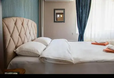 a bedroom with a large white bed and a window at Family Hotel Victoria Gold in Mineralni Bani
