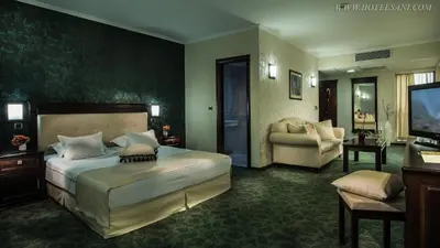 a bedroom with a large bed and a living room at Hotel Sani in Asenovgrad