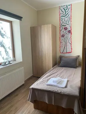 a bedroom with a bed and a cabinet and a window at Hotel Forest Star on the Ski Slope in Borovets