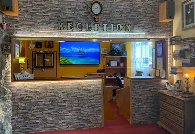 an office with a reception desk and a tv on a brick wall at Hotel Forest Star on the Ski Slope in Borovets