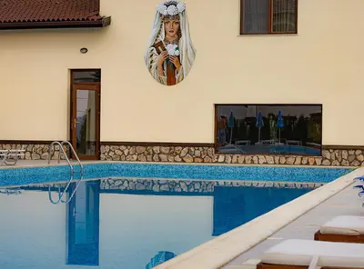 a swimming pool in a house with a painting on the wall at Eco Hotel Momata in Kolarovo