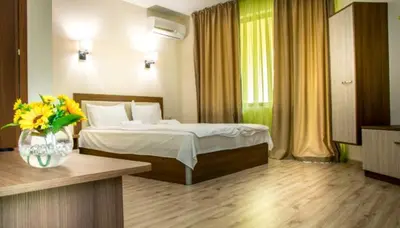 a bedroom with a bed and a vase of flowers at Eco Hotel Momata in Kolarovo