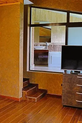 a kitchen with a staircase and a large window at Holiday House Kubrat in Sapareva Banya