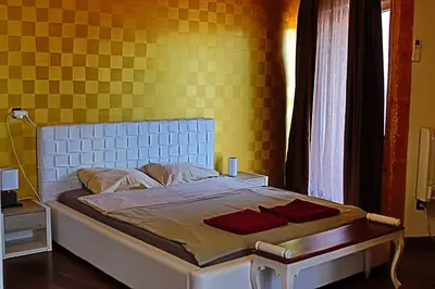 a bedroom with a bed with a yellow wall at Holiday House Kubrat in Sapareva Banya
