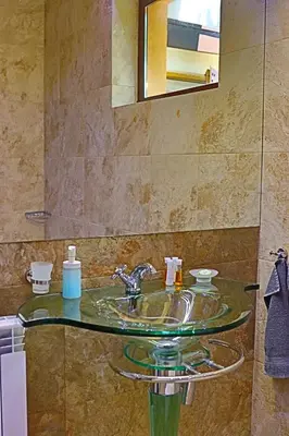 a bathroom with a glass sink and a mirror at Holiday House Kubrat in Sapareva Banya