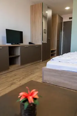 a room with a bedroom with a bed and a television at La Casa Hotel in Tsigov Chark