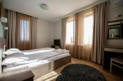 a bedroom with a large bed and a large window at La Casa Hotel in Tsigov Chark