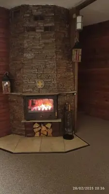 a fireplace in a room with a stone wall at Guest House Diva Reka in Beli Iskar