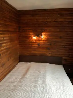 a bed in a room with wooden walls at Guest House Diva Reka in Beli Iskar
