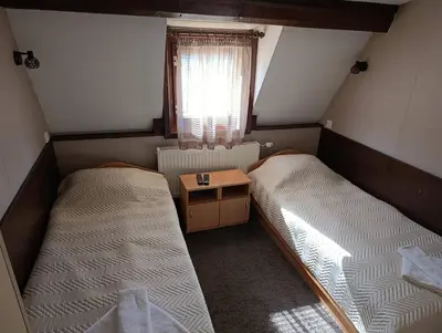 a small room with two beds and a window at Guest House Diva Reka in Beli Iskar