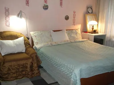 a bedroom with a bed and a chair at Kamigs Rooms in Sofia