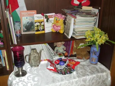 a shelf with a table with toys and flowers on it at Kamigs Rooms in Sofia