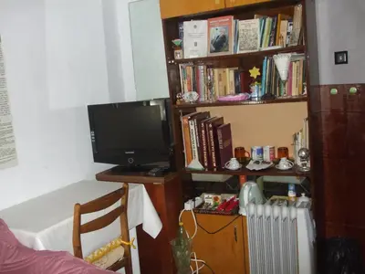 a living room with a tv and a book shelf at Kamigs Rooms in Sofia