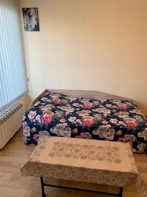 a bedroom with a bed with a floral blanket at Like Home Guest Rooms in Sofia