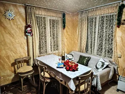 a dining room with a table and a couch at Guest House Emiliya in Ovchartsi