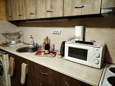 a kitchen counter with a microwave and a sink at Guest House Emiliya in Ovchartsi