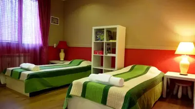 two beds in a room with red and green at Parkview Apartments in Sofia