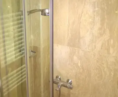 a shower stall with a glass door with a shower constructorangering at Parkview Apartments in Sofia